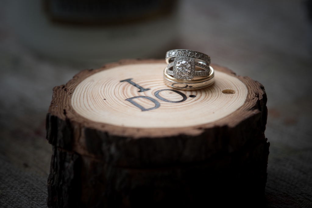Diamond engagement ring and wedding bands on a wooden ring box