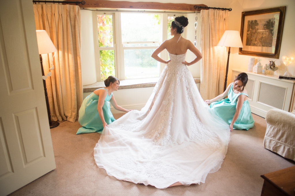 Bridesmaids fixing the Brides wedding dress