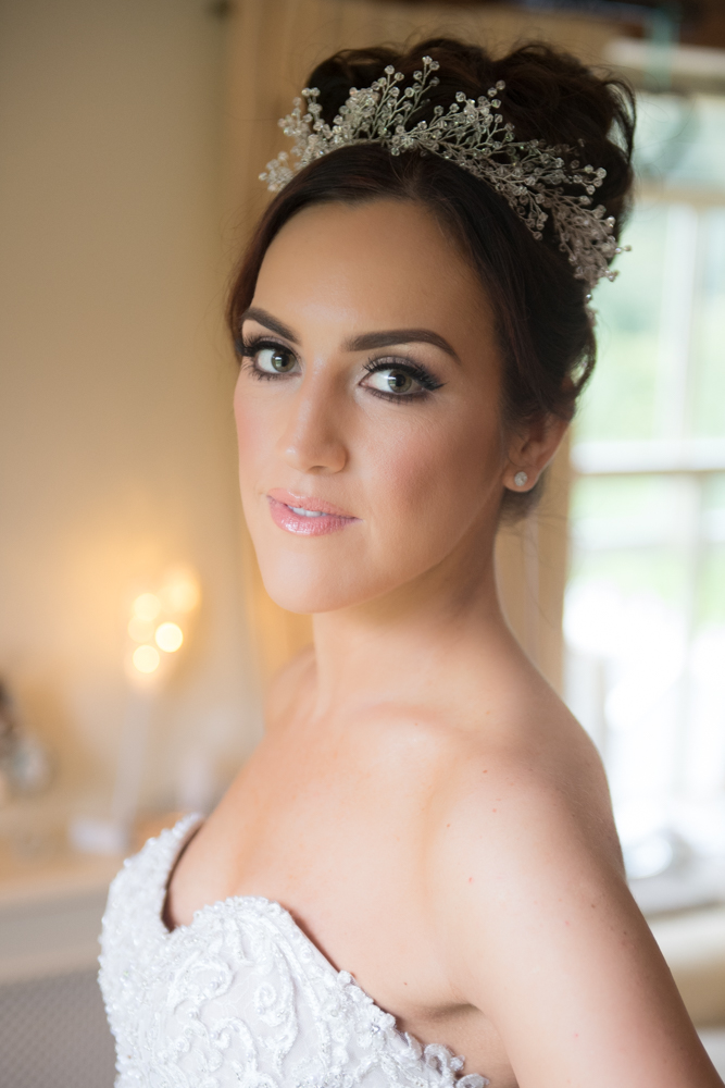 Bride looking at camera wearing her wedding dress and hair piece