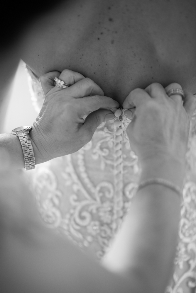 Bride getting her dress being tied up