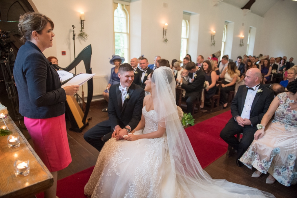 Bride and groom smiling at each other during their wedding ceremony