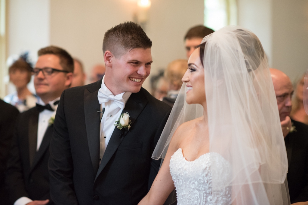 Bride and groom smiling at each other during their wedding ceremony