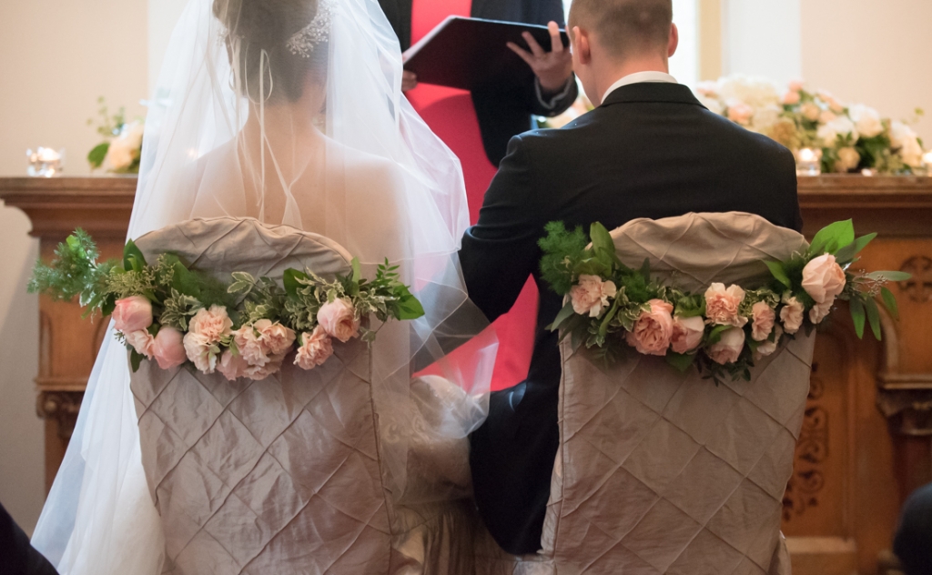 Flowers on the back of the chairs during their wedding ceremony