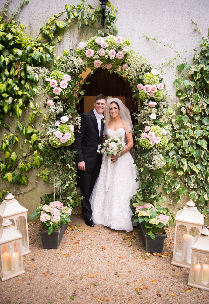 Bride and groom in the flower arch at the Brooklodge wedding chapel