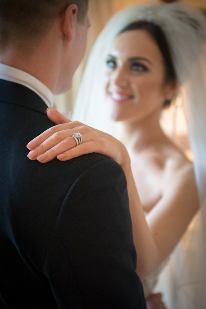 The brides engagement and wedding ring on her hand