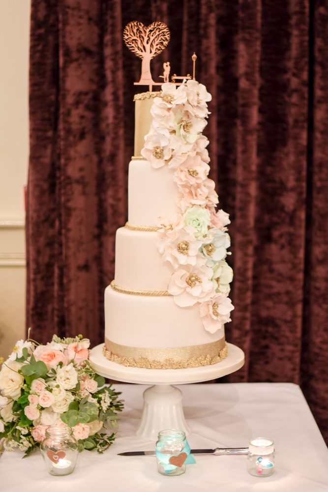Four tier cream and gold wedding cake