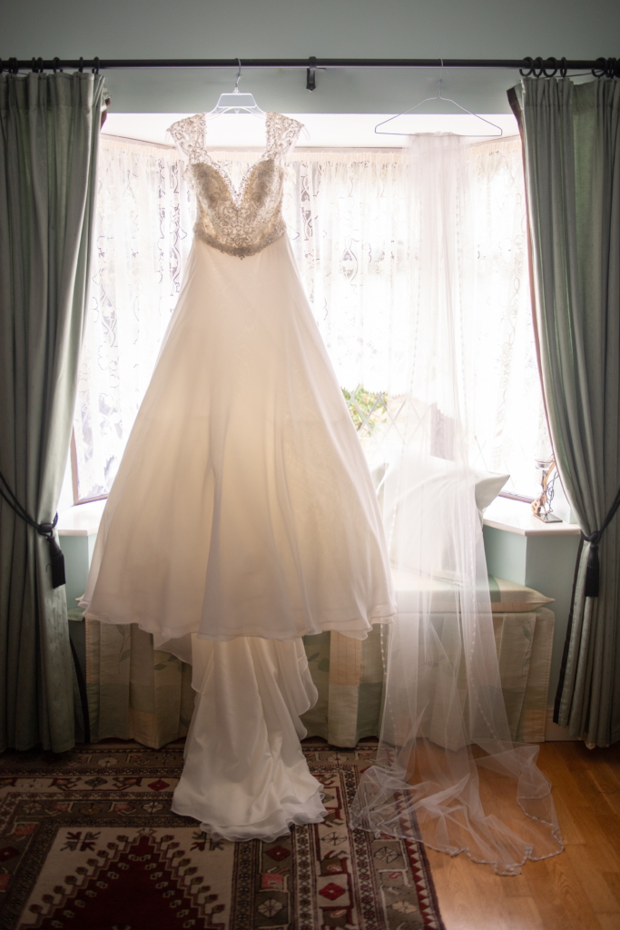 radisson blu wedding wedding dress hanging up in window by wedding photographers the fennells