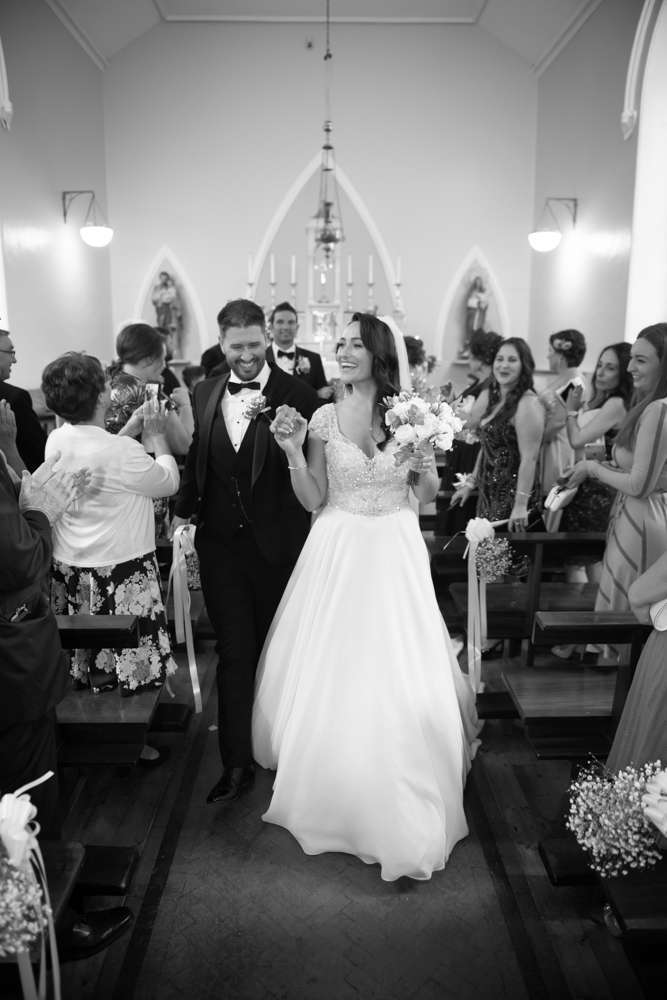 walking down aisle black and white photo by wedding photographers the fennells radisson blu wedding