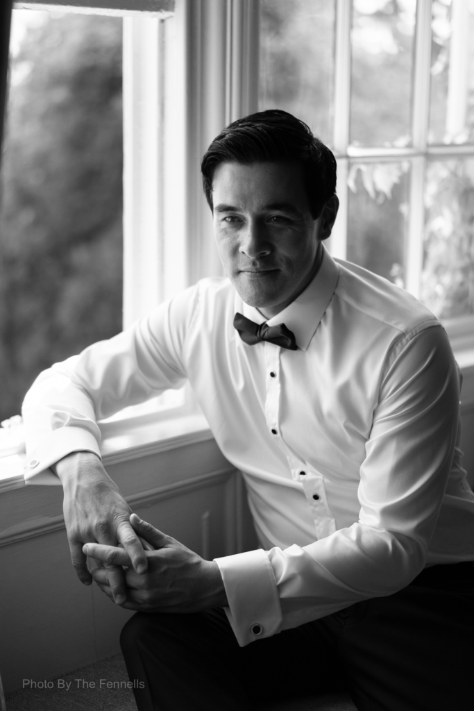 James Stewart sitting by the window in his wedding shirt and bow tie at Luttrellstown Castle