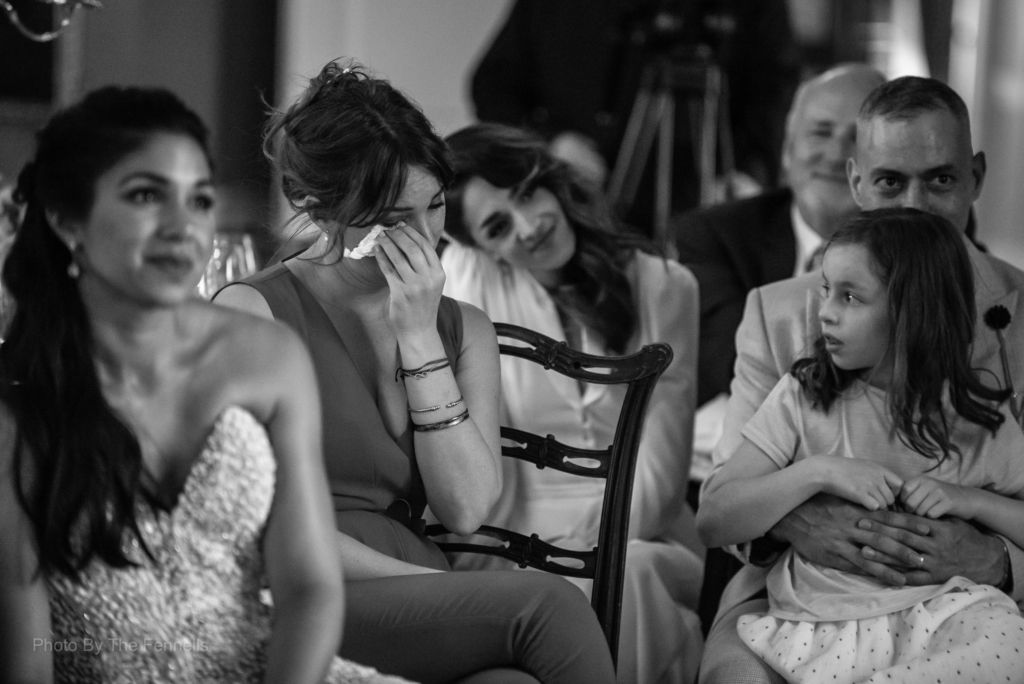 Wedding guest wiping her tears away while listening to the wedding speeches at the home and away wedding