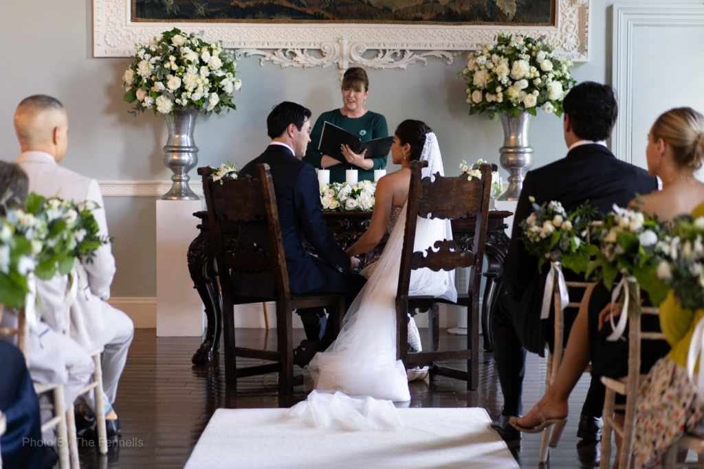 Sarah Roberts and James Stewart holding hands sitting during their ceremony