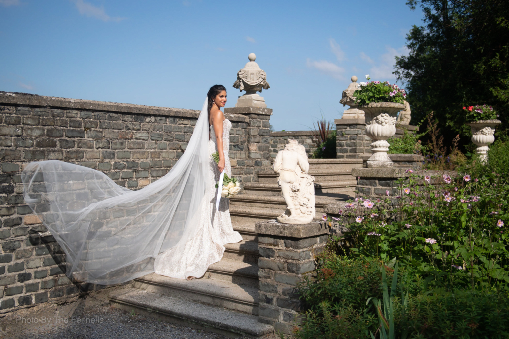 Sarah Roberts standing on the steps of Luttrellstown Castle with her veil flowing