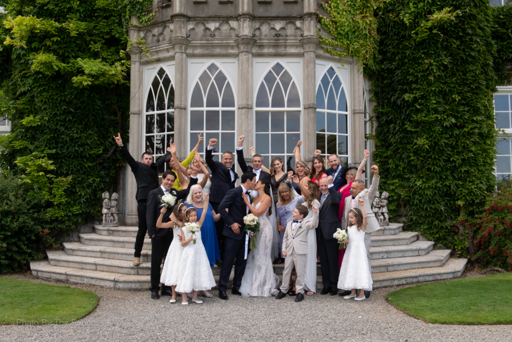 Sarah Roberts and James Stewart with their wedding guests outside on the steps of Luttrellstown Castle