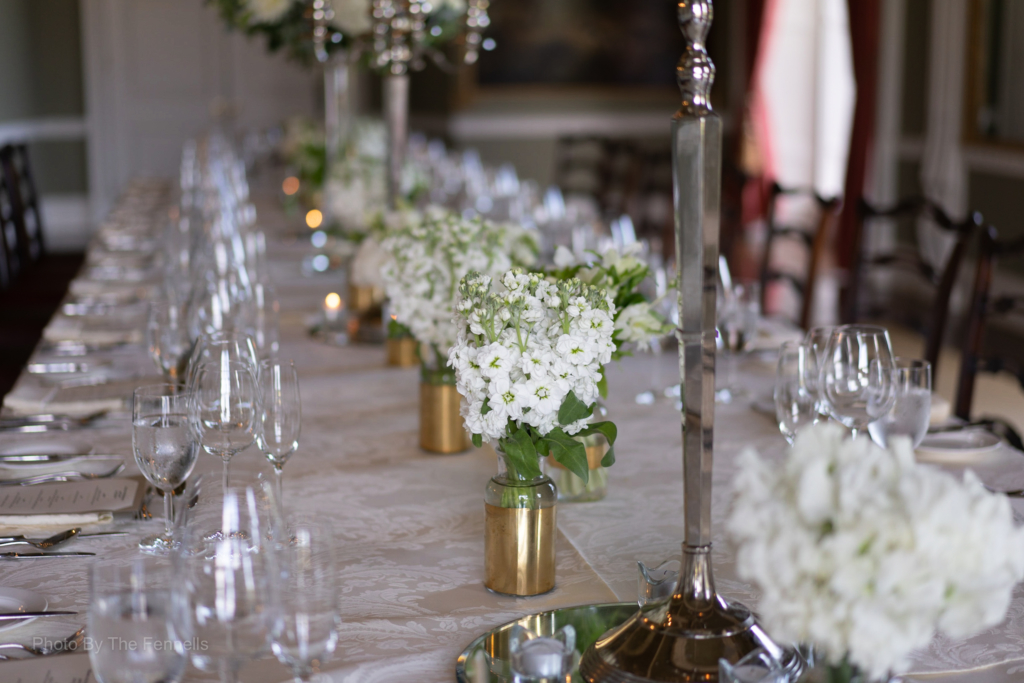 The white flowers on the table setting for the home and away wedding