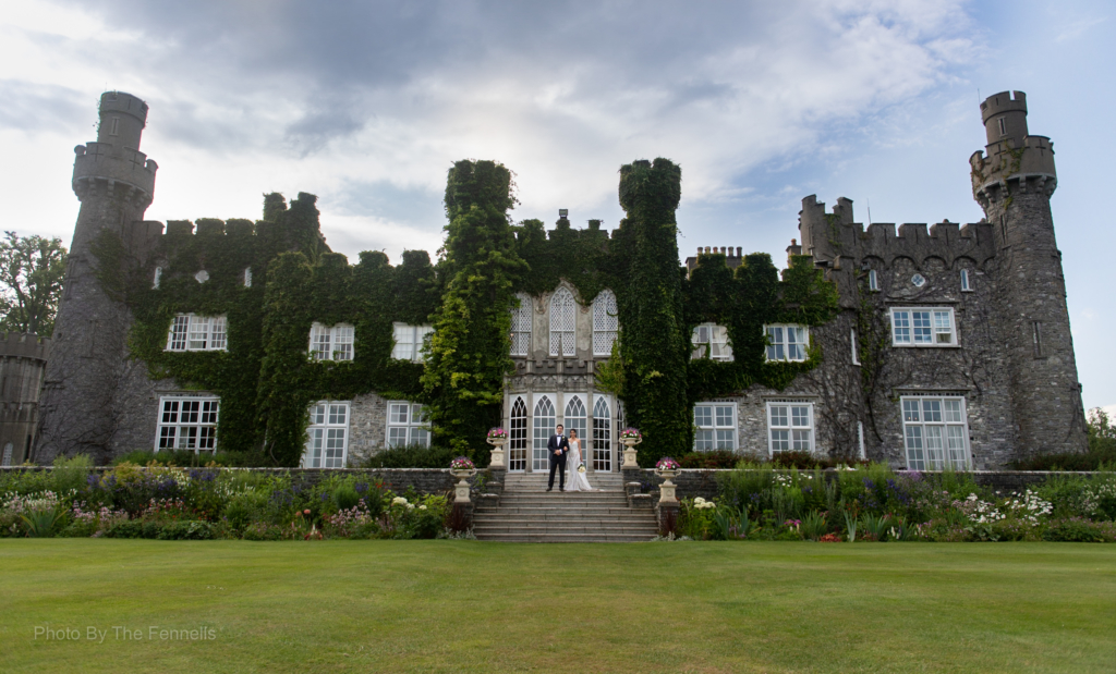 Sarah Roberts and James Stewart standing outside the steps at Luttrellstown Castle on their wedding day