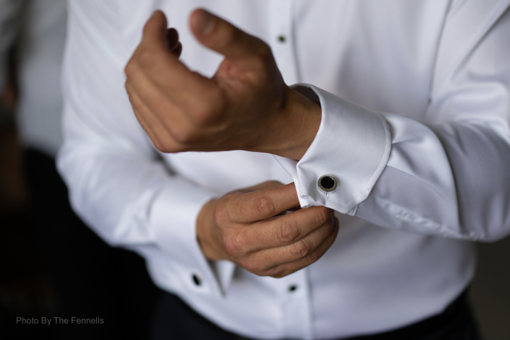 James Stewart putting on wedding cuff links