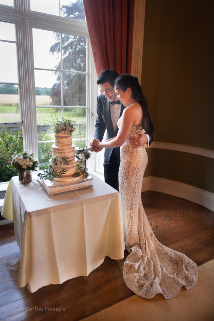 Sarah Roberts and James Stewart cutting their wedding cake 