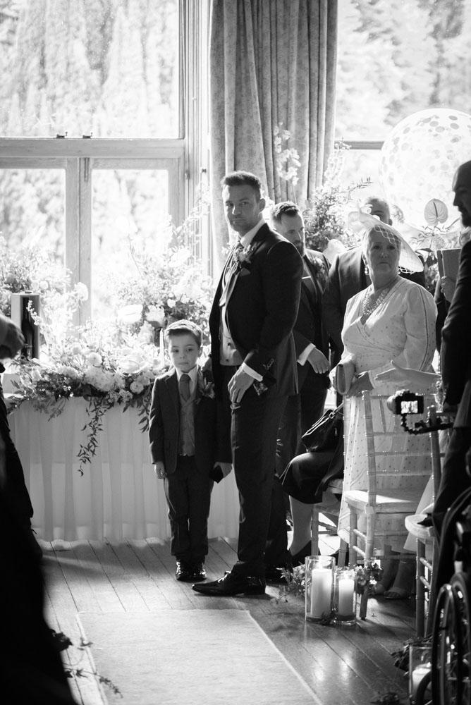 Groom and son looking at Bride walking down the aisle at Castle Leslie