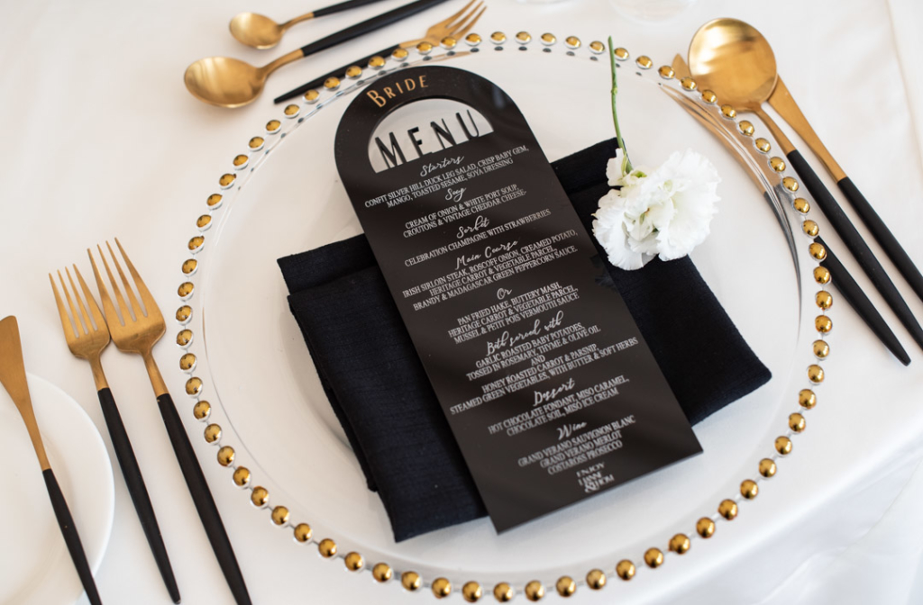 Wedding dinner menu on plate with white flower