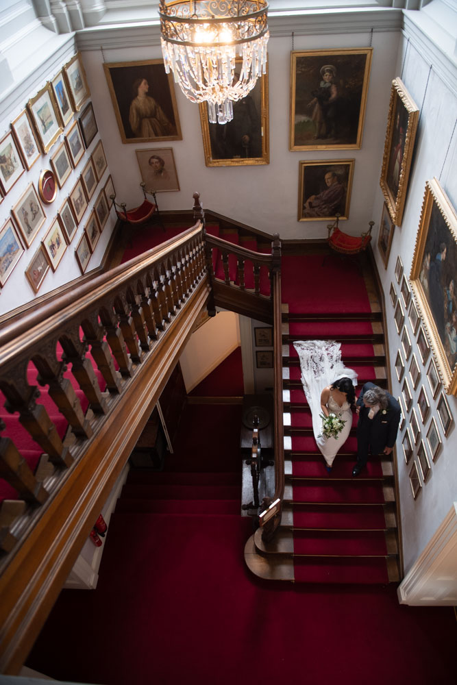 Bride walking down the stairs with her dad at castle leslie