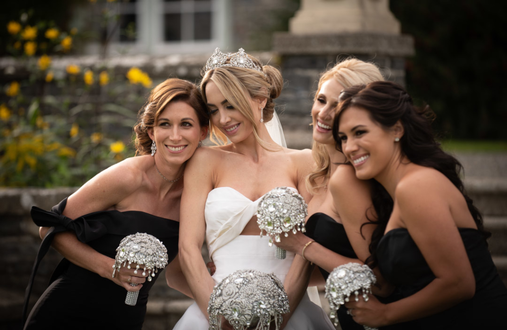 bride and bridesmaids holding diamanté bouquets laughing together