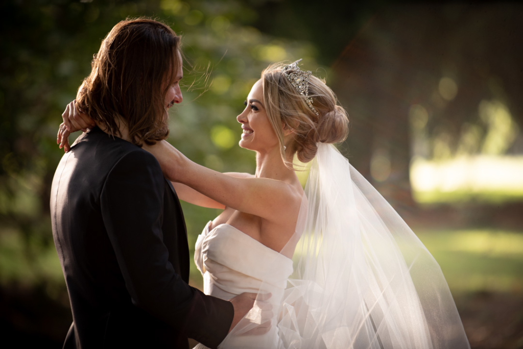 bride hugging and smiling with groom outside castle