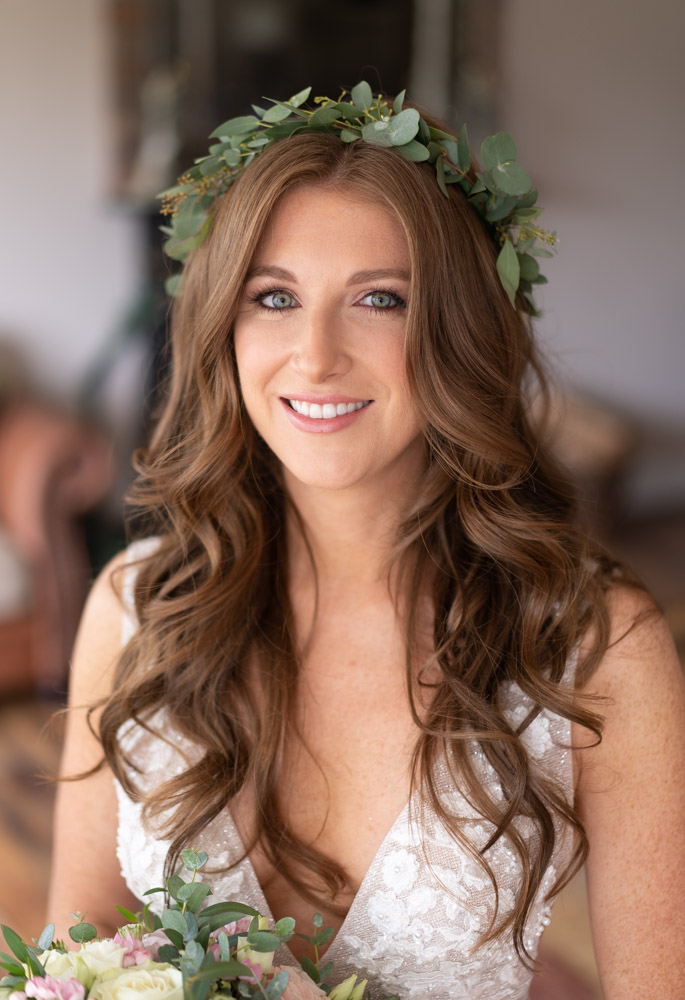 Bride with long red curly hair and a green flower crown on her head