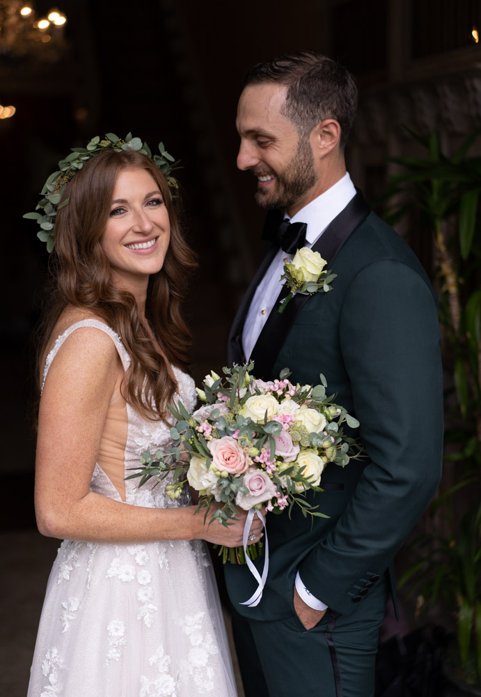 Bride smiling looking at camera and groom smiling looking at her