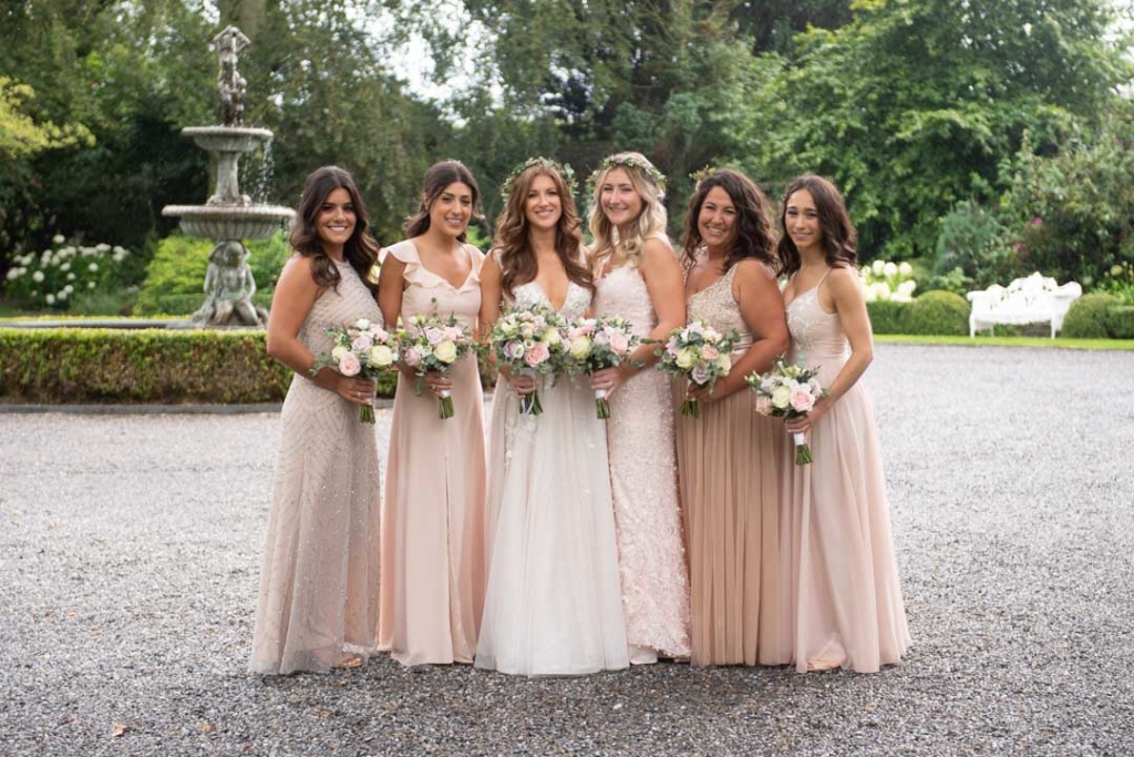 Bride and Bridesmaids in blush dresses holding flowers at Ballymagarvey