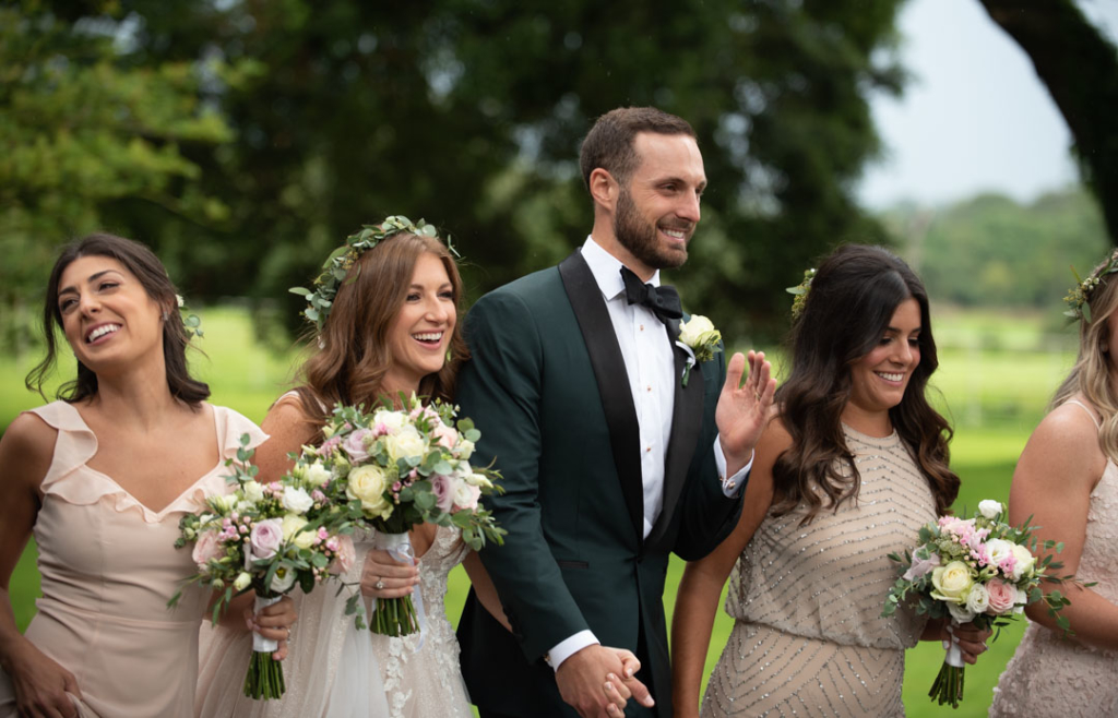 Bride and Groom walking and laughing with their bridal party