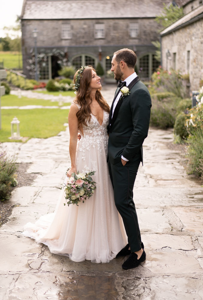 Bride and Groom standing looking at each other in the courtyard at Ballymagarvey Village