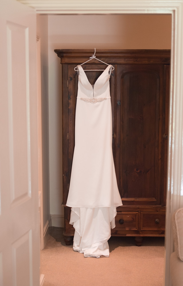 White wedding dress hanging up on wardrobe