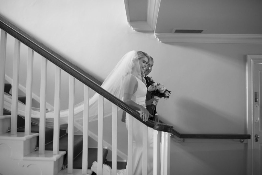 Bride and her dad walking down the stairs together in Brooklodge