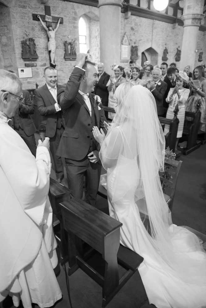 Bride and groom celebrating after saying their vows with the guests clapping