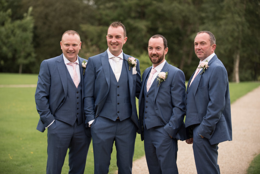 Groom and groomsmen standing together on the grounds of Brooklodge