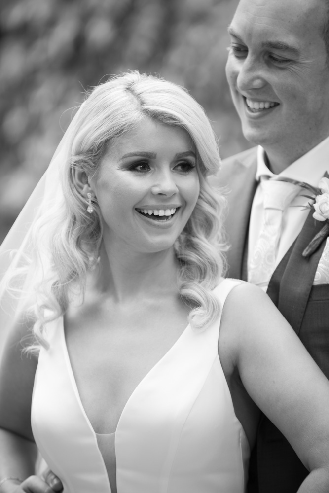 Black and white of bride and groom laughing