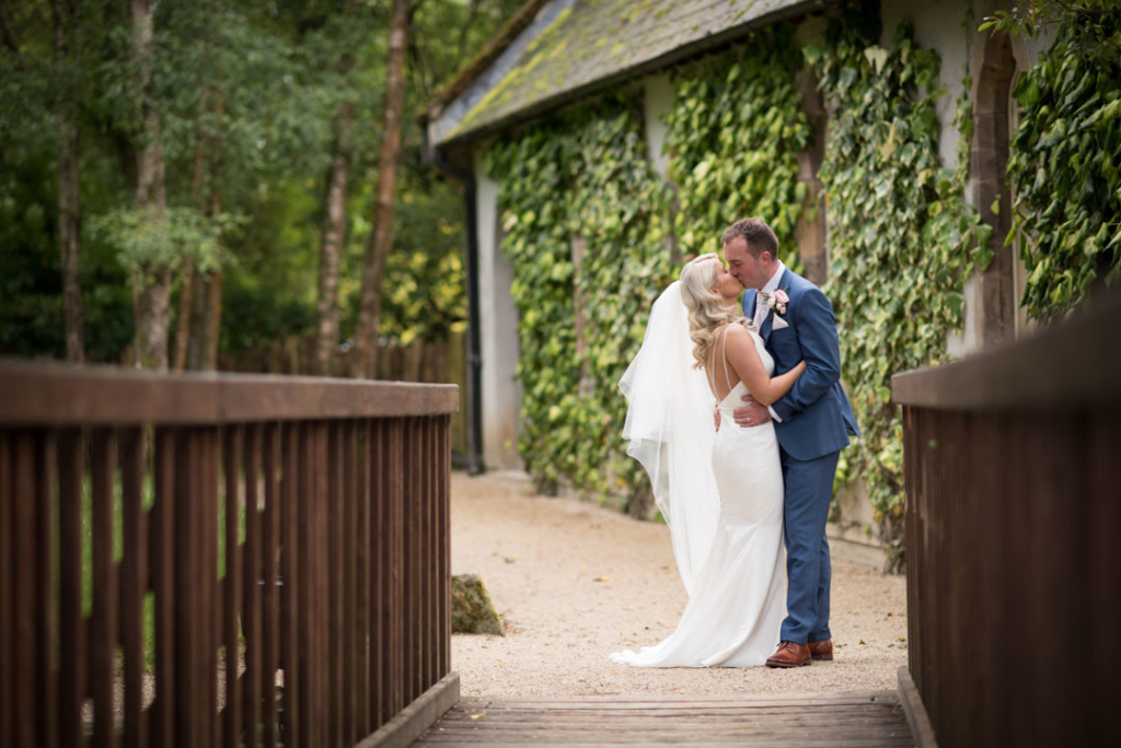 Bride and groom kissing on the grounds of Brooklodge