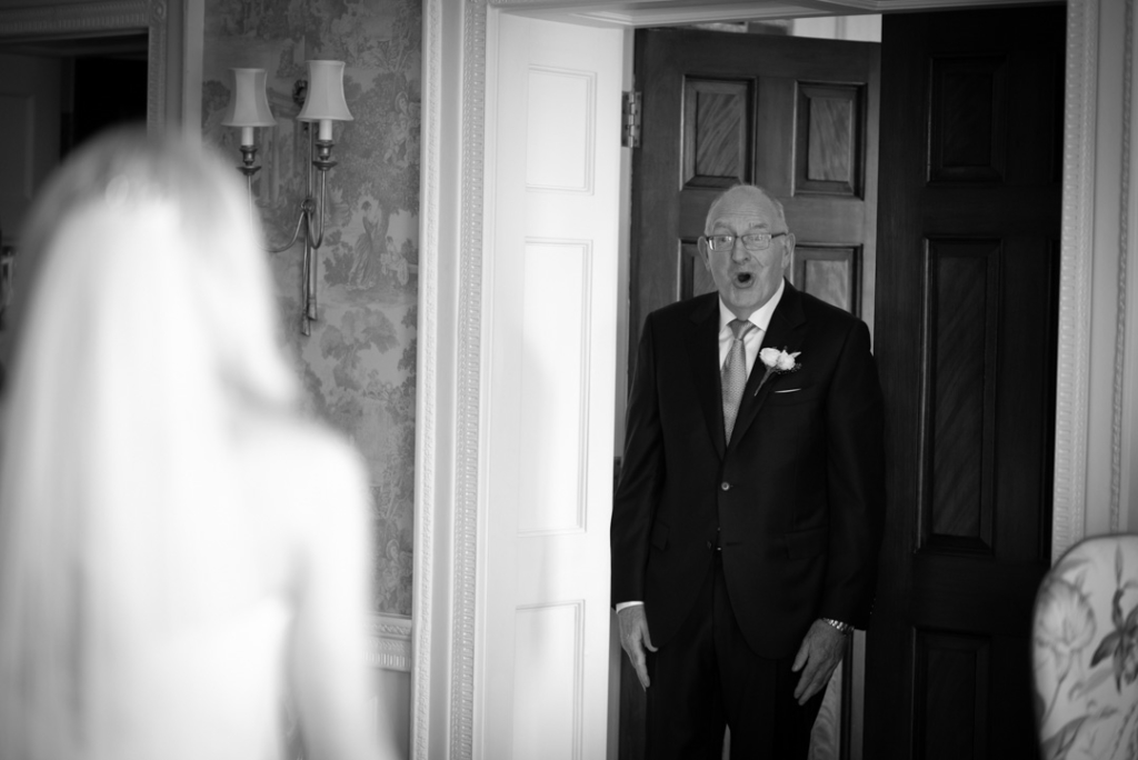 Father of the brides seeing his daughter in her wedding dress for the first time