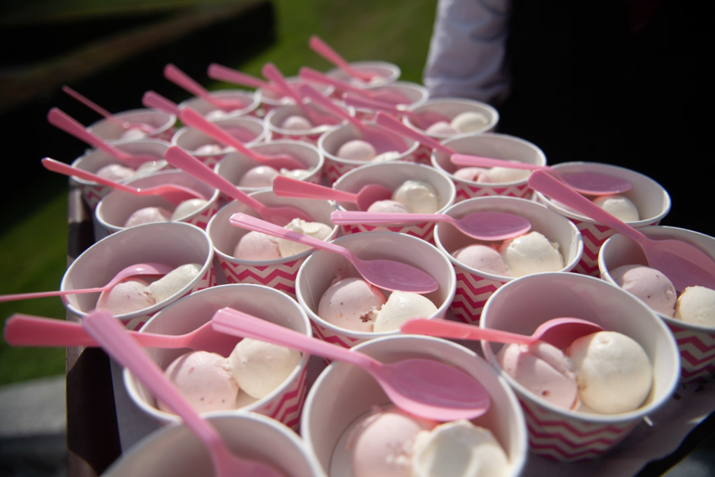 Vanilla and strawberry ice-cream in cups with pink spoons