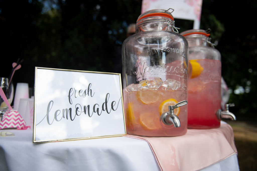 Fresh lemonade sign with pink lemonade in glass jars