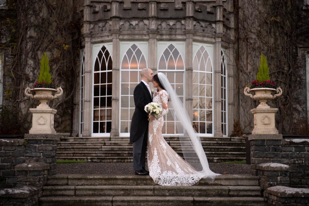 Groom kissing Brides head outside on the steps of Luttrellstown Castle