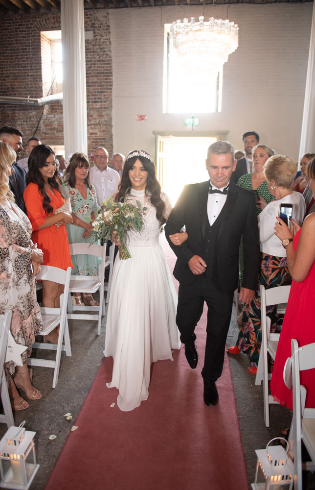 Bride and her dad walking up the aisle for the wedding ceremony at the Mill House Slane