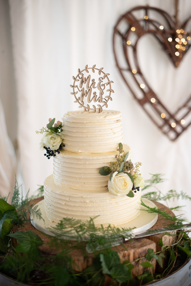 White three tier wedding cake with white rose flowers