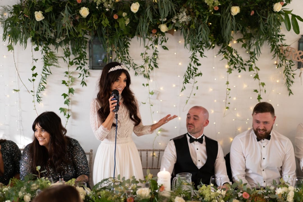 Bride standing at the top table while giving her speech