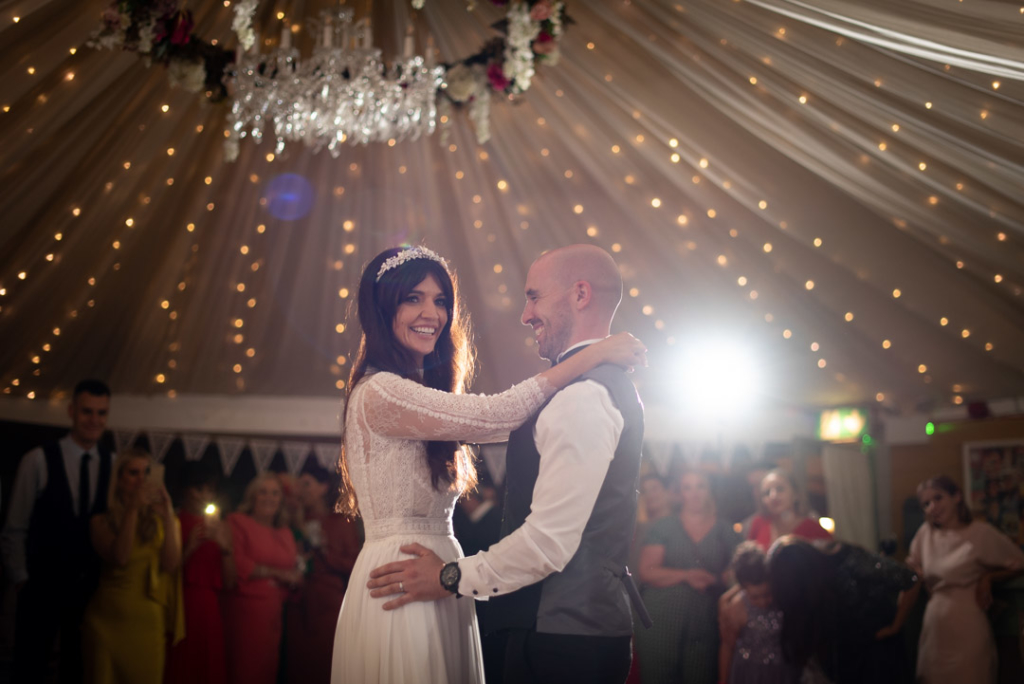 Bride and groom smiling and dancing to their first dance
