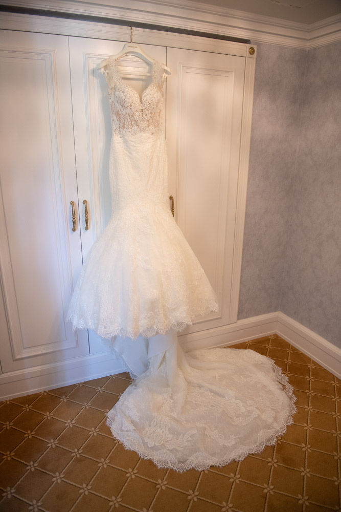 Lace wedding dress hanging on the outside of the wardrobe