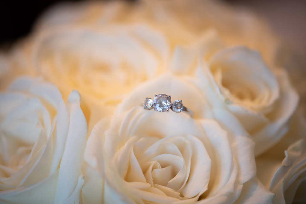 Engagement ring with three diamonds on white roses