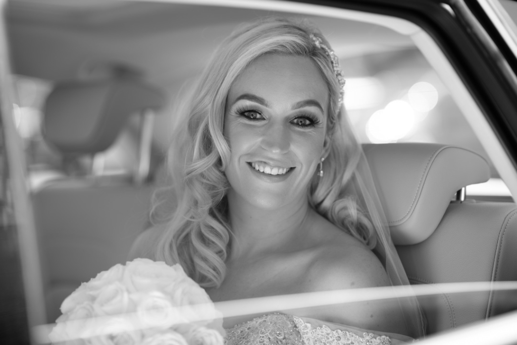 Bride sitting in the back of the wedding car arriving at the Church