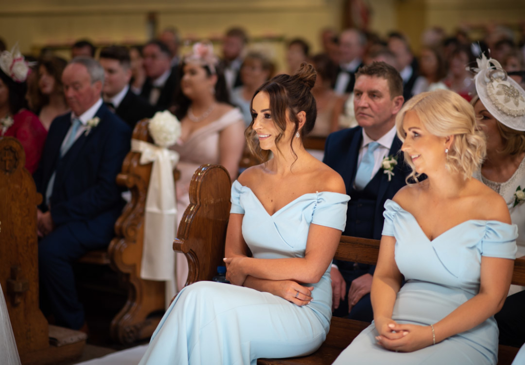 Bridesmaids sitting in the Church in their baby blue dresses