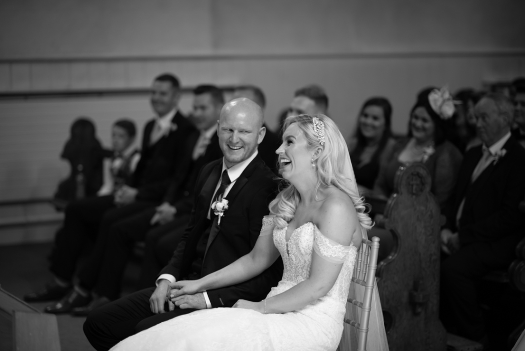 The Bride and Groom sitting and laughing together in the Church